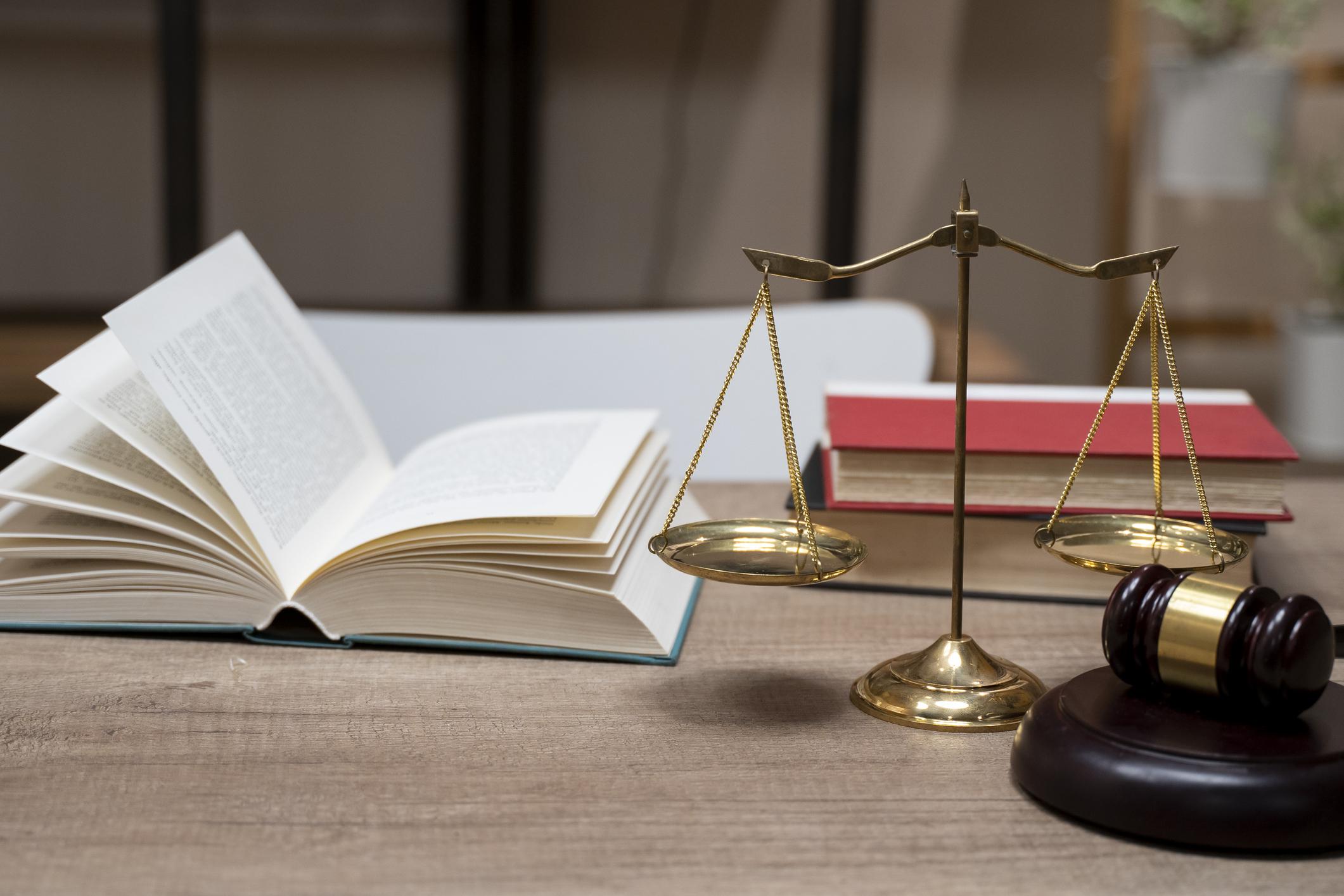 Law and justice concept depicted by open book and gavel on wooden table.